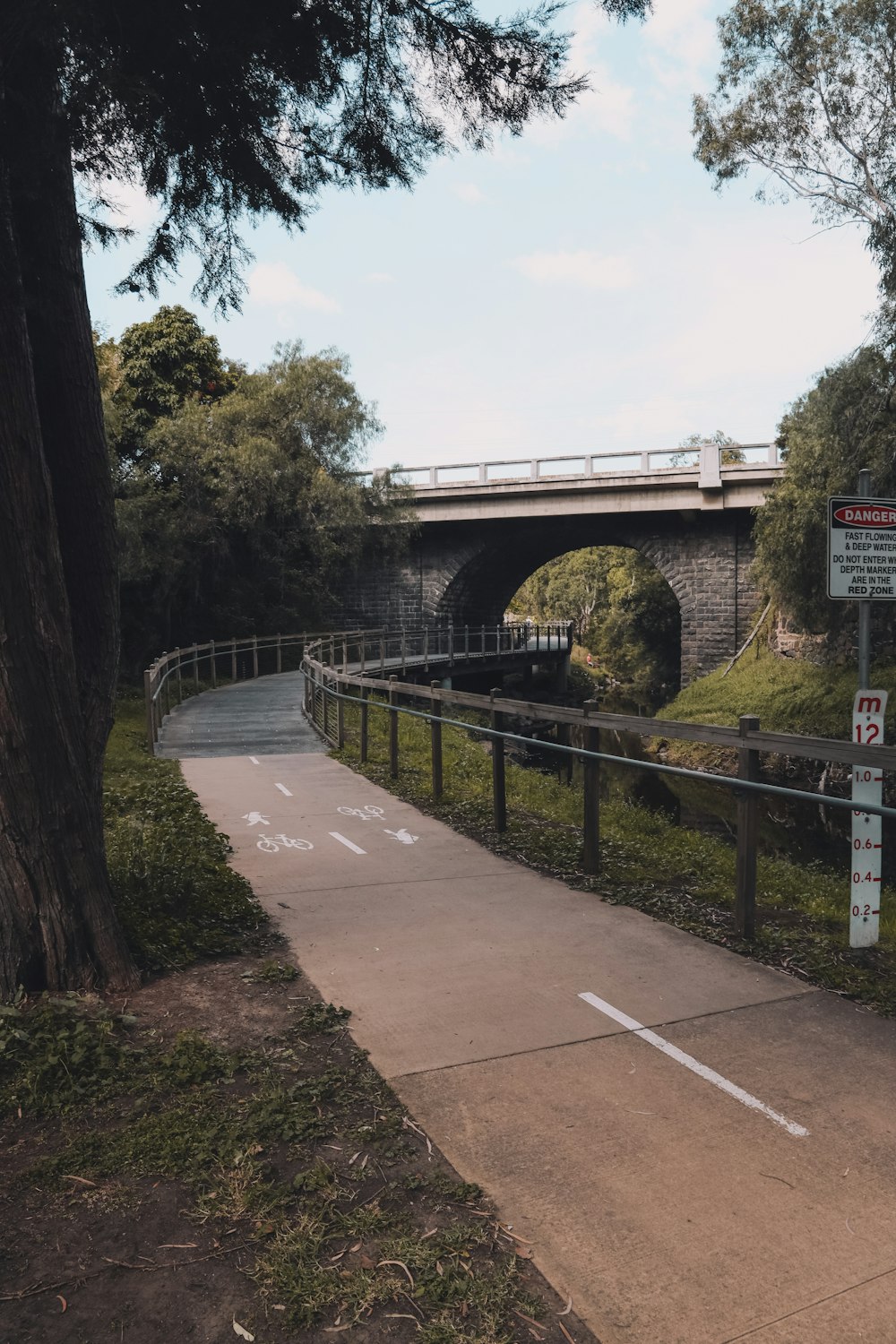 gray concrete bridge near green trees during daytime