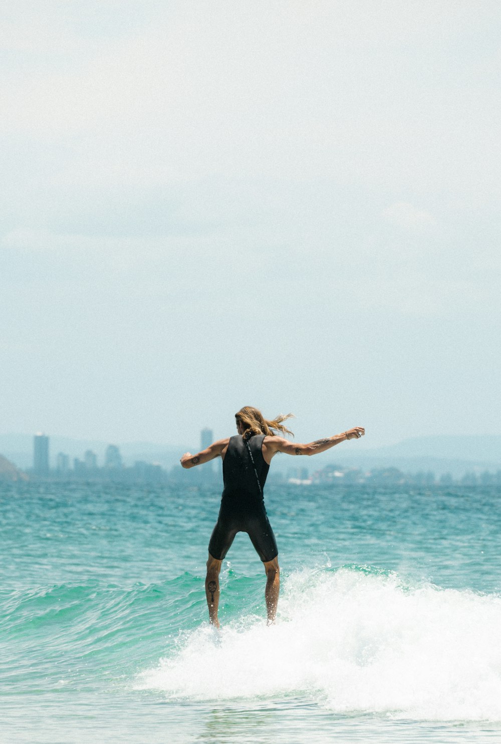 woman in black tank top and black leggings jumping on water during daytime