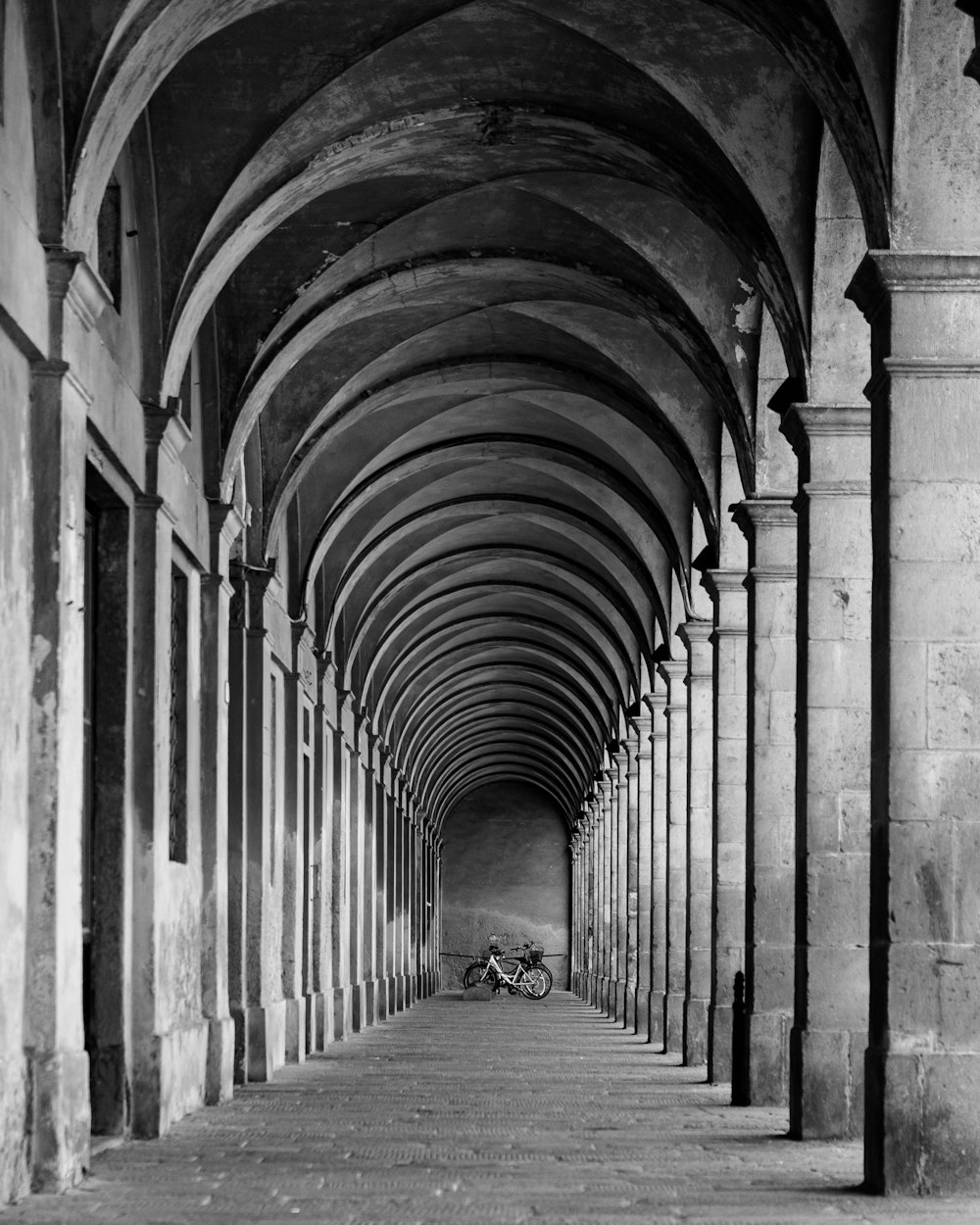 grayscale photo of person walking on hallway