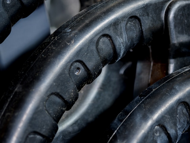 Close-up view of black rubber material with a textured pattern. The surface has grooves and dimples, suggestive of industrial machinery or equipment.