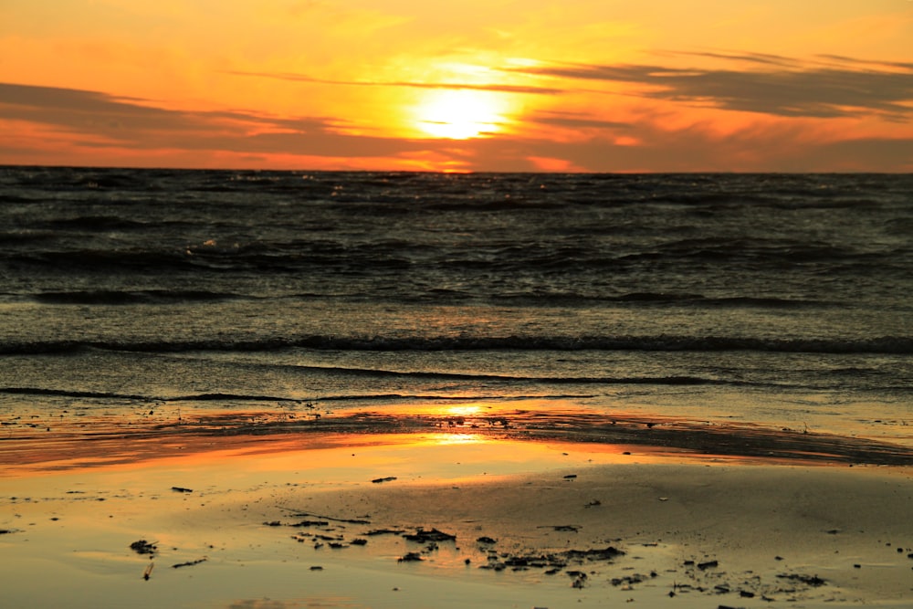 ocean waves crashing on shore during sunset