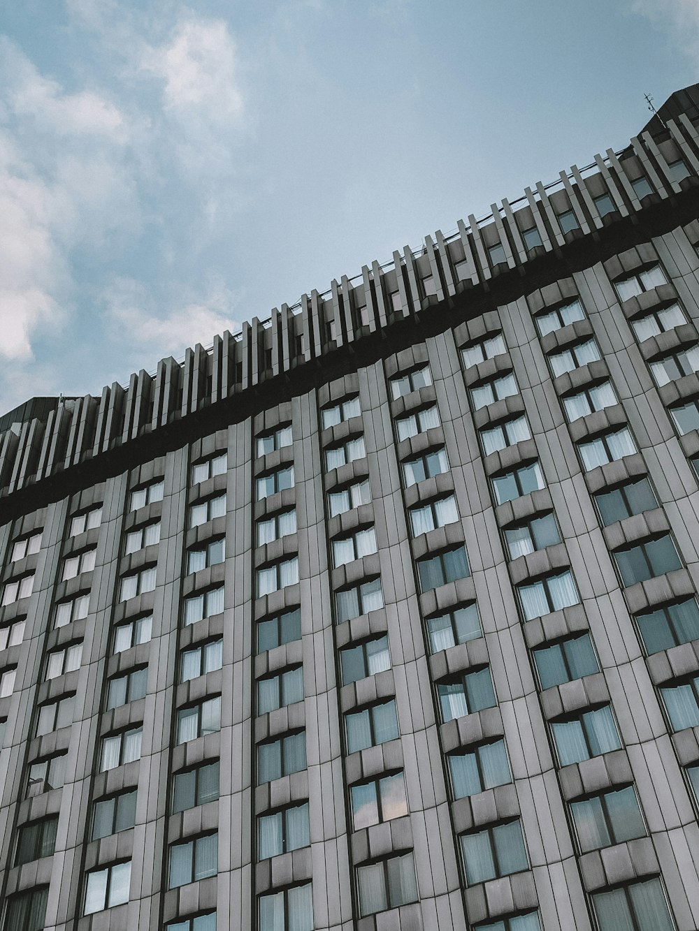 gray concrete building under white clouds during daytime