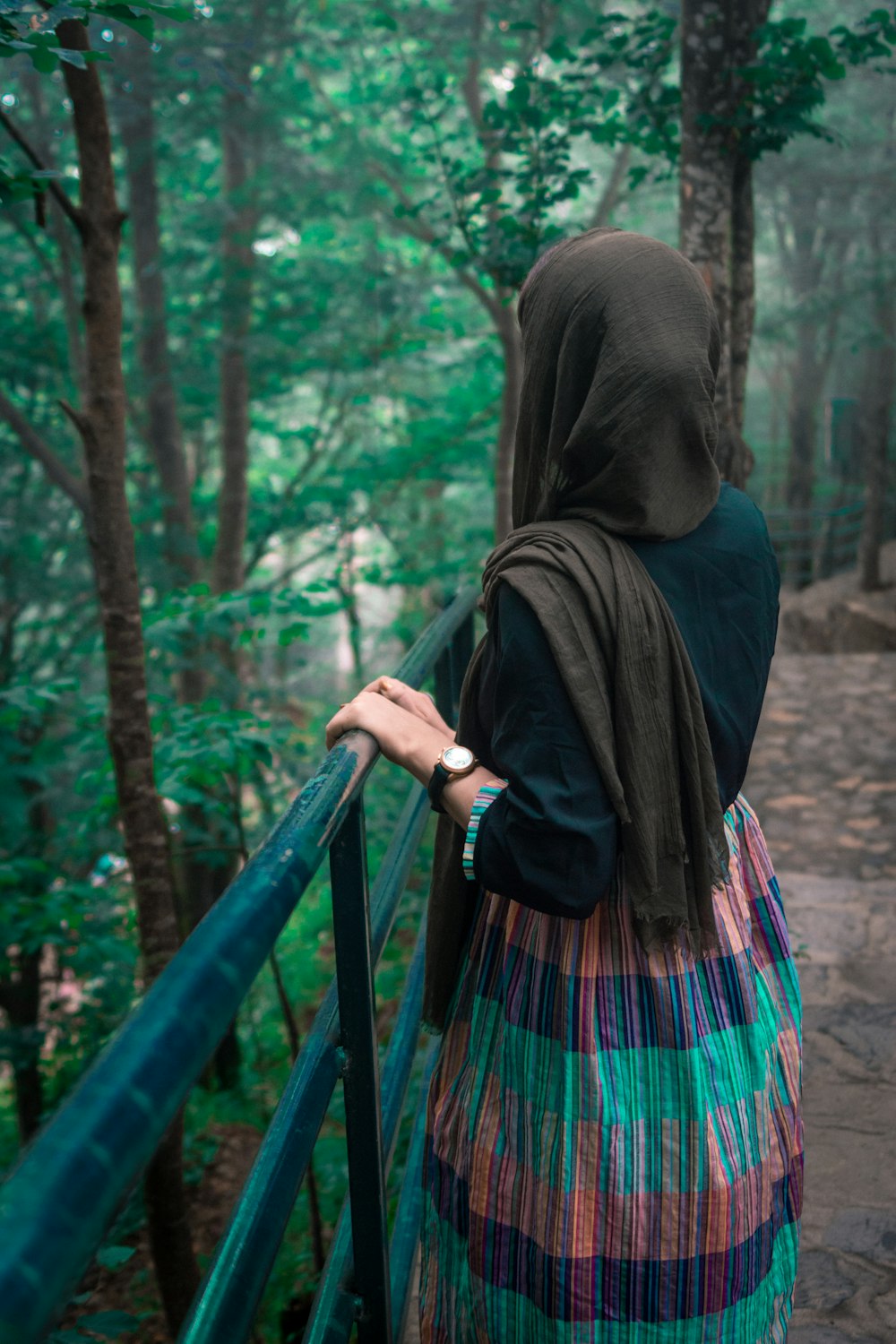 mulher no hijab preto em pé na floresta durante o dia
