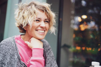 smiling girl in pink shirt and gray cardigan