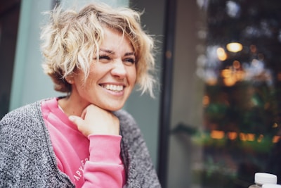 smiling girl in pink shirt and gray cardigan