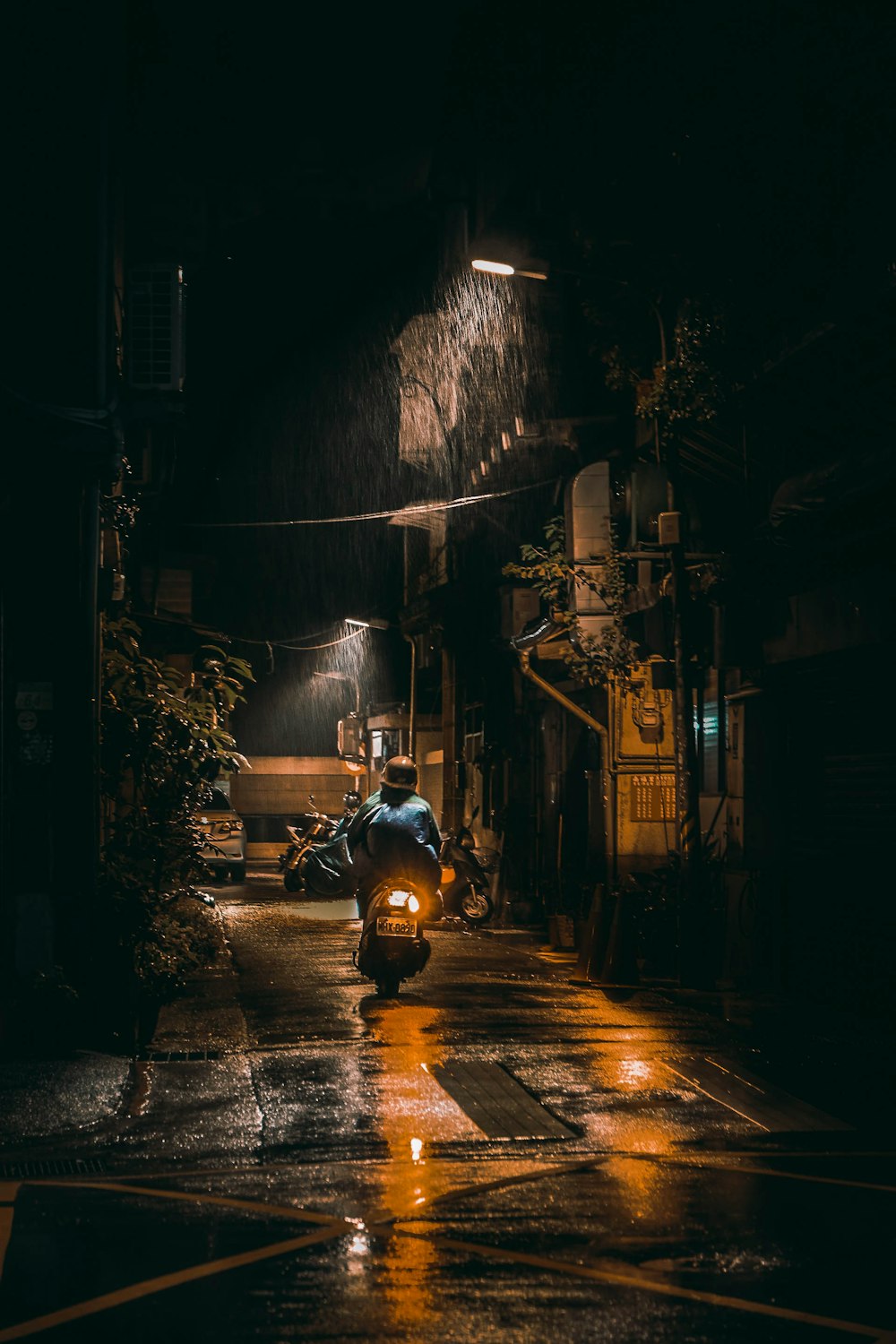 man in black jacket riding motorcycle on road during nighttime