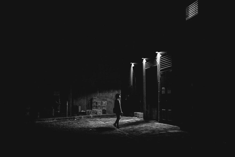 grayscale photo of man walking on street