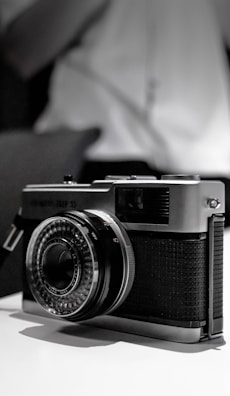 A stylish vintage camera resting on a rustic surface.
