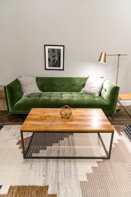 brown wooden table near green sofa