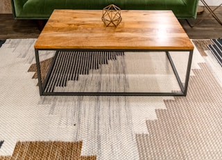 brown wooden table near green sofa