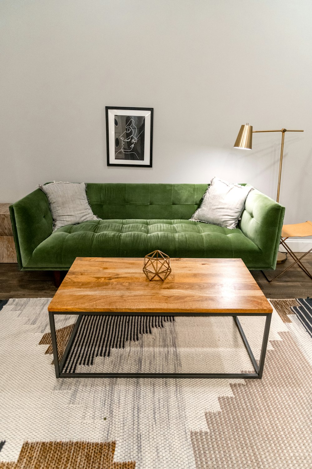 brauner Holztisch in der Nähe des grünen Sofas