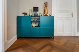 green wooden cabinet with figurines