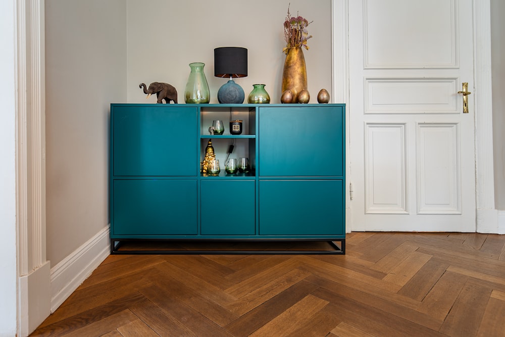 Mueble de madera verde con figuritas