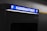 A parking payment machine is partially visible, with a brightly lit sign in blue displaying the word 'Kassenautomat' and the letter 'P' on both sides. The surrounding area is dimly lit, emphasizing the illuminated sign.
