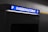 A parking payment machine is partially visible, with a brightly lit sign in blue displaying the word 'Kassenautomat' and the letter 'P' on both sides. The surrounding area is dimly lit, emphasizing the illuminated sign.