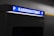 A parking payment machine is partially visible, with a brightly lit sign in blue displaying the word 'Kassenautomat' and the letter 'P' on both sides. The surrounding area is dimly lit, emphasizing the illuminated sign.