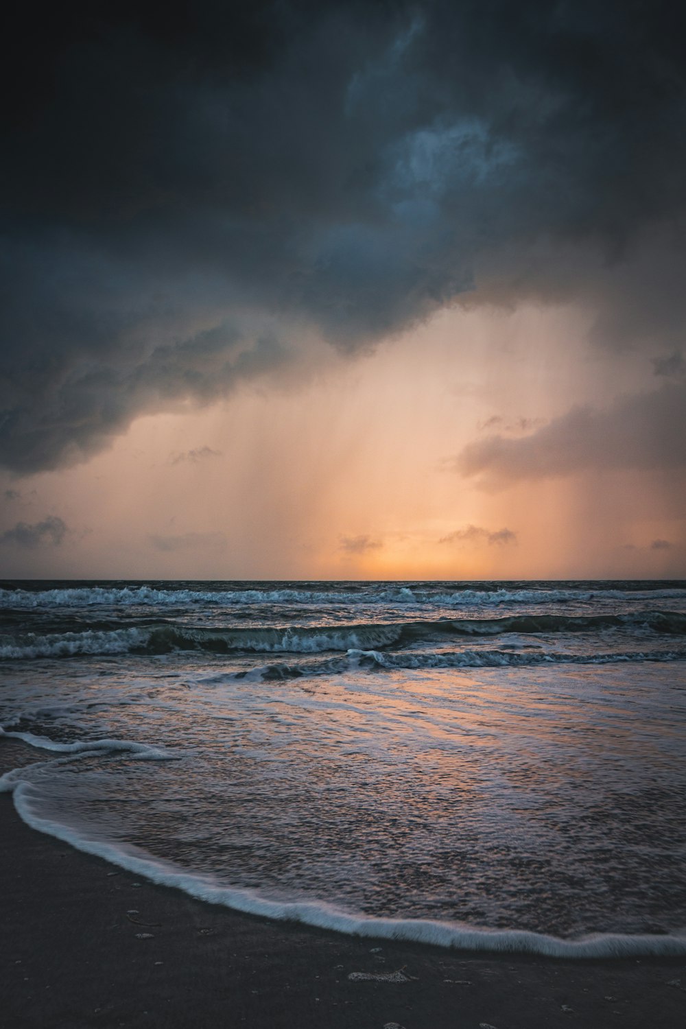 ocean waves crashing on shore during sunset