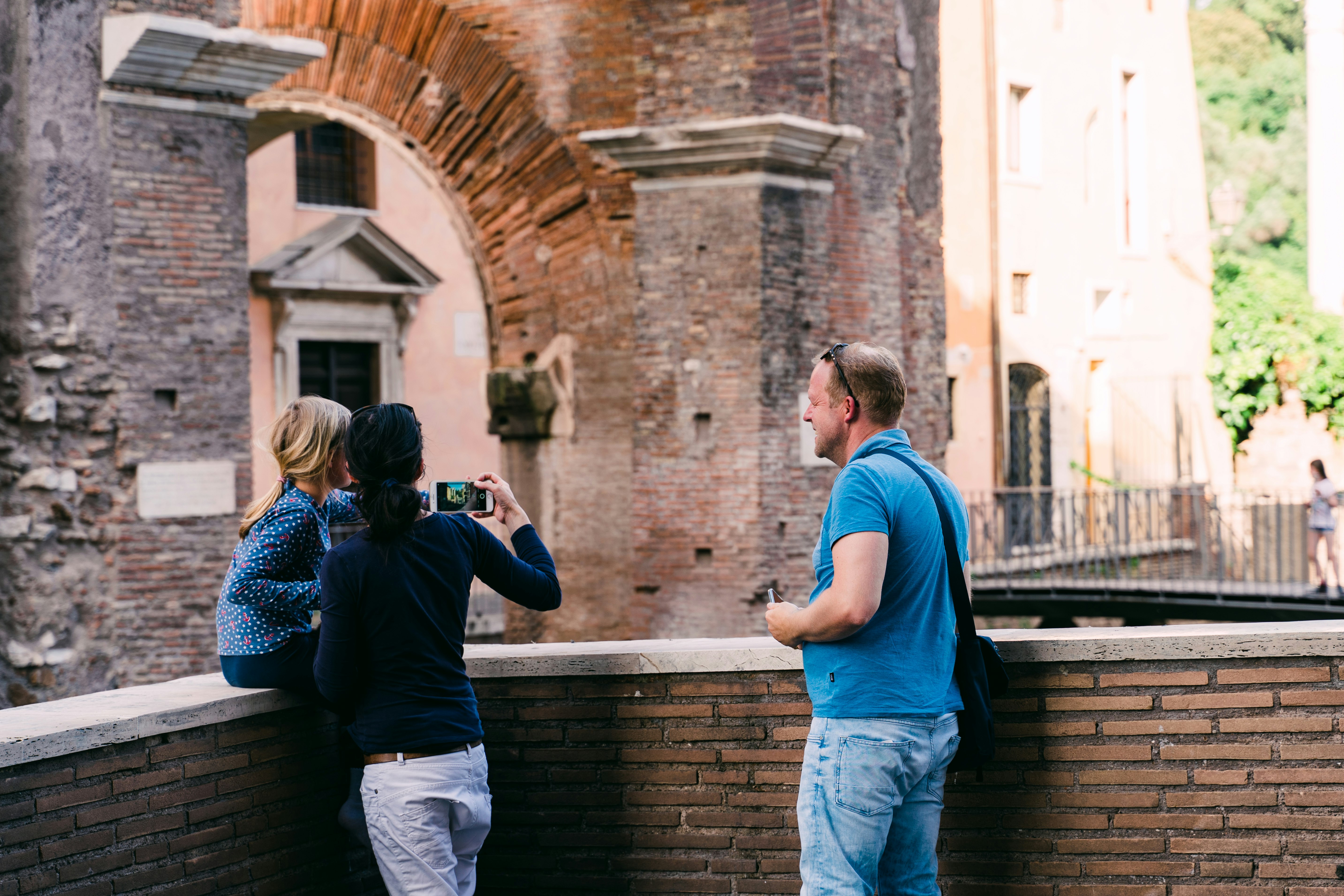 man in blue t-shirt and blue denim jeans holding black dslr camera