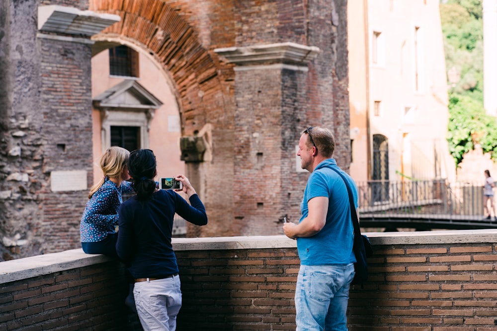 man in blue t-shirt and blue denim jeans holding black dslr camera