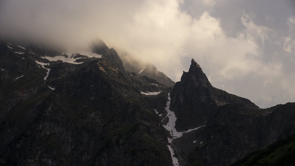 Montagnes noires et blanches sous des nuages blancs