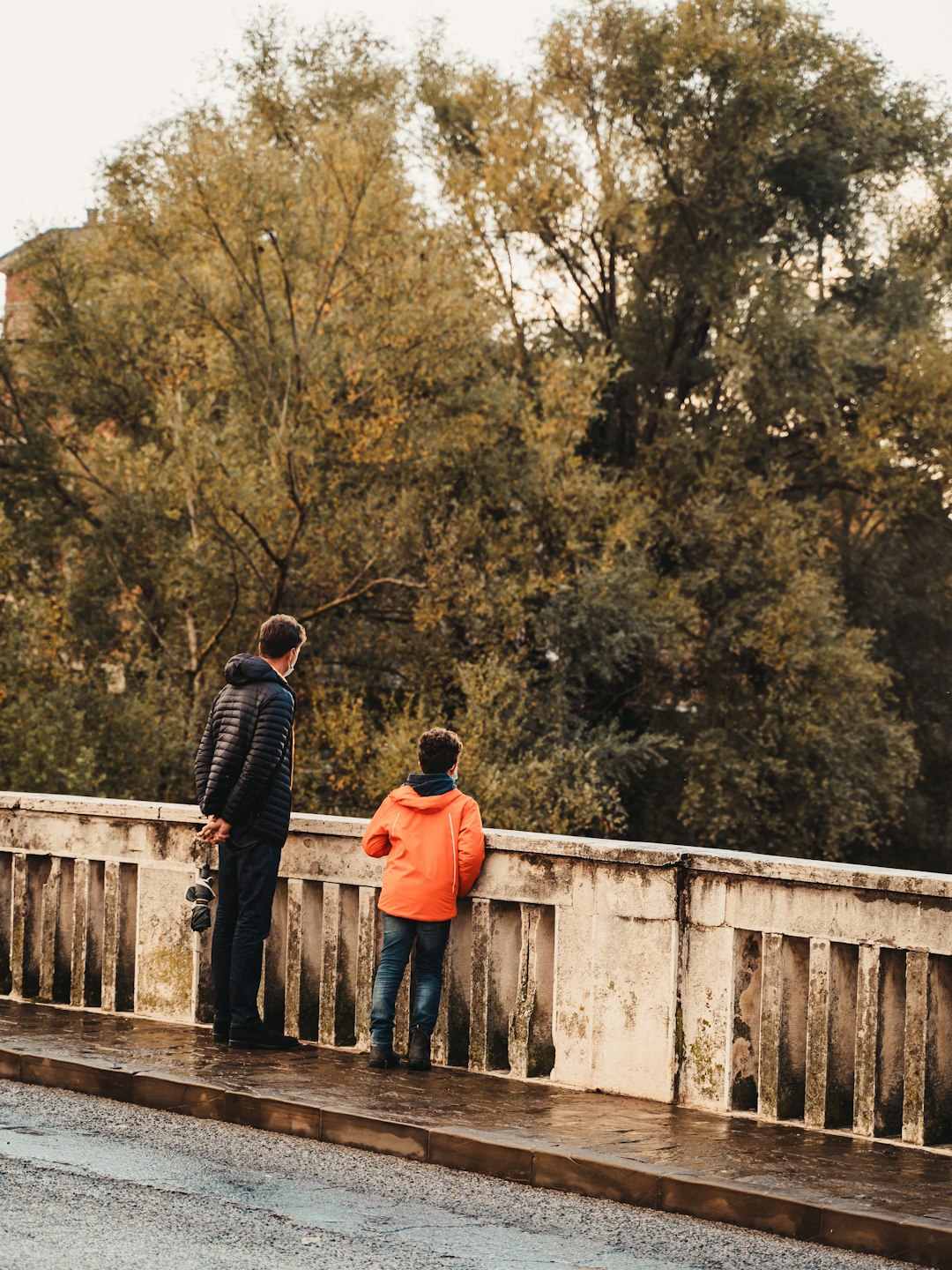 man and woman standing on wooden bridge during daytime