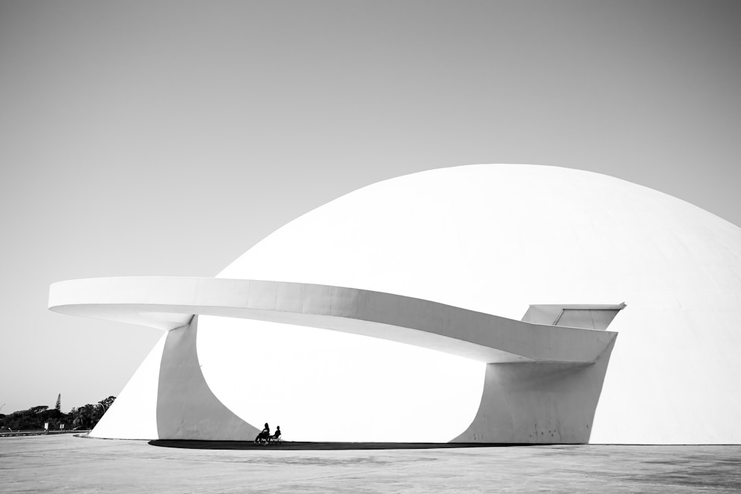 man in black jacket walking on white concrete building,