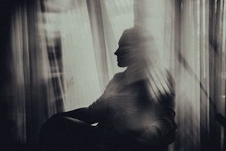 woman sitting on chair near window