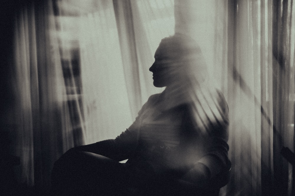 man sitting on chair near window