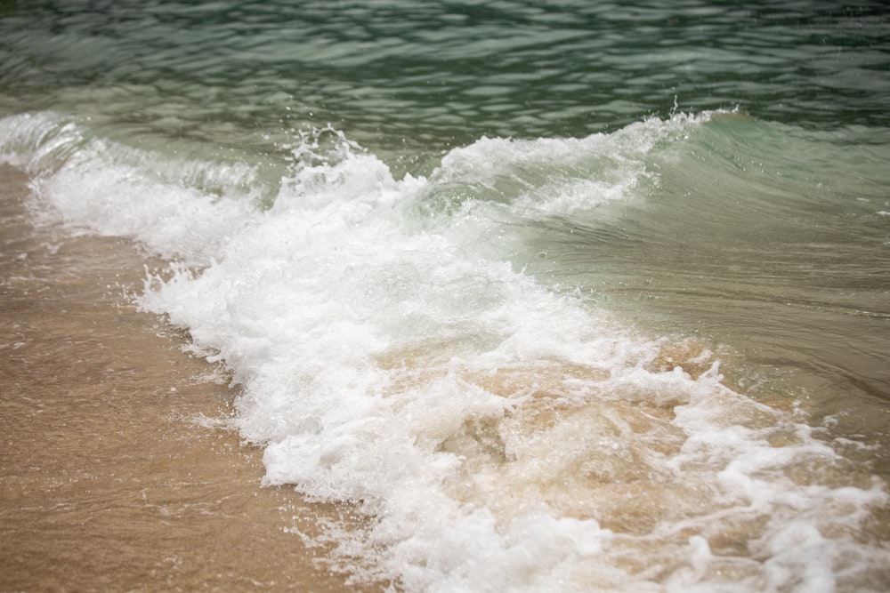 ocean waves crashing on shore during daytime