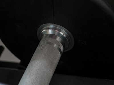 Close-up of a barbell collar securely locking weight plates in place.