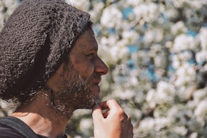 Man i svart-vit stickad mössa som tänker