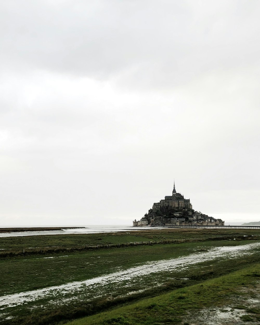 castello nero sul campo di erba verde sotto il cielo bianco durante il giorno