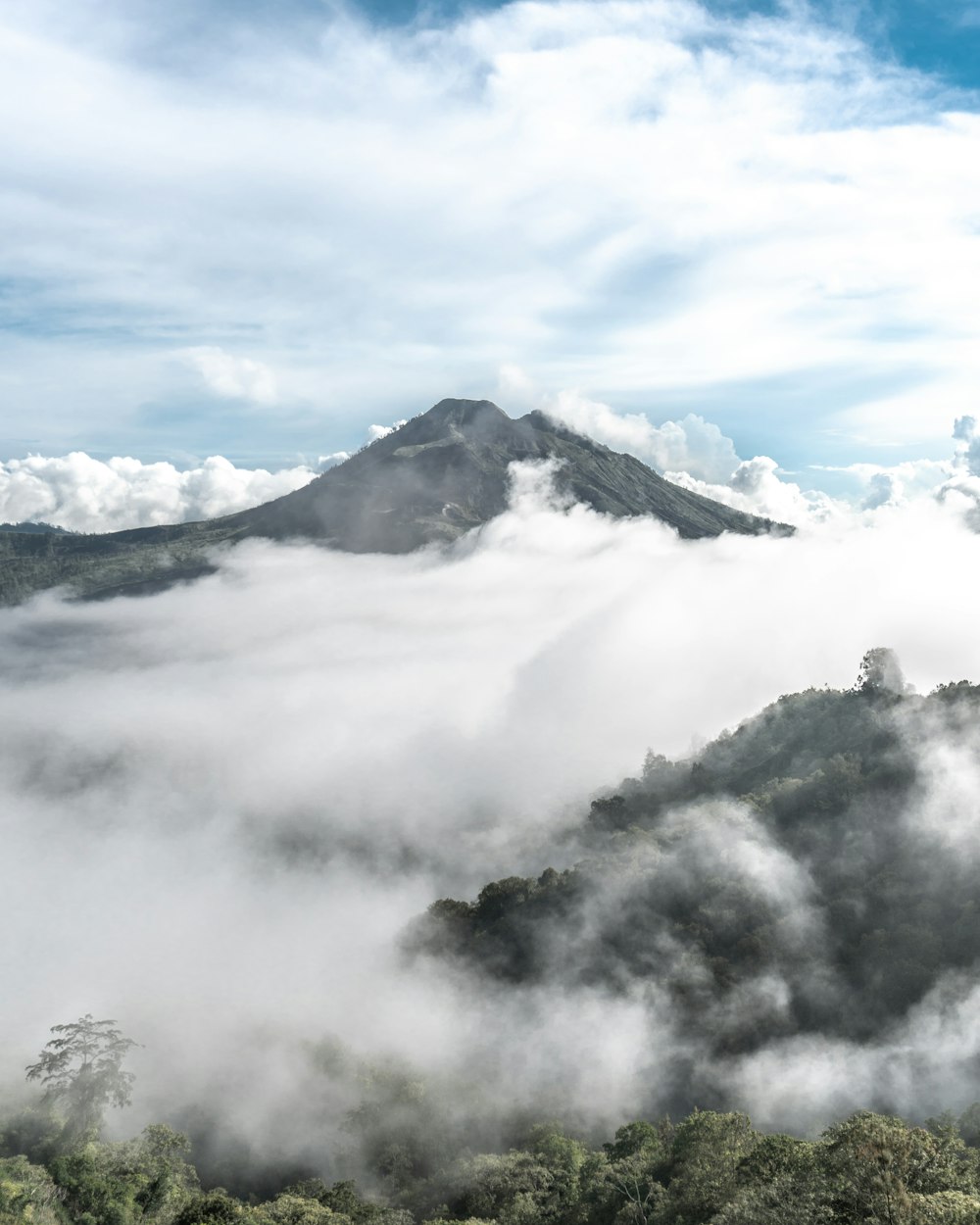 green mountain under white clouds during daytime