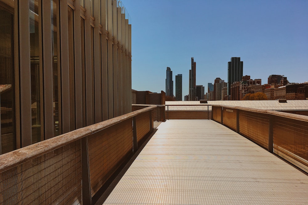 brown wooden fence near high rise buildings during daytime