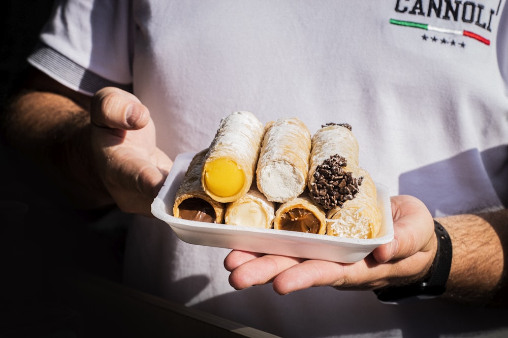 person holding white plastic container with bread