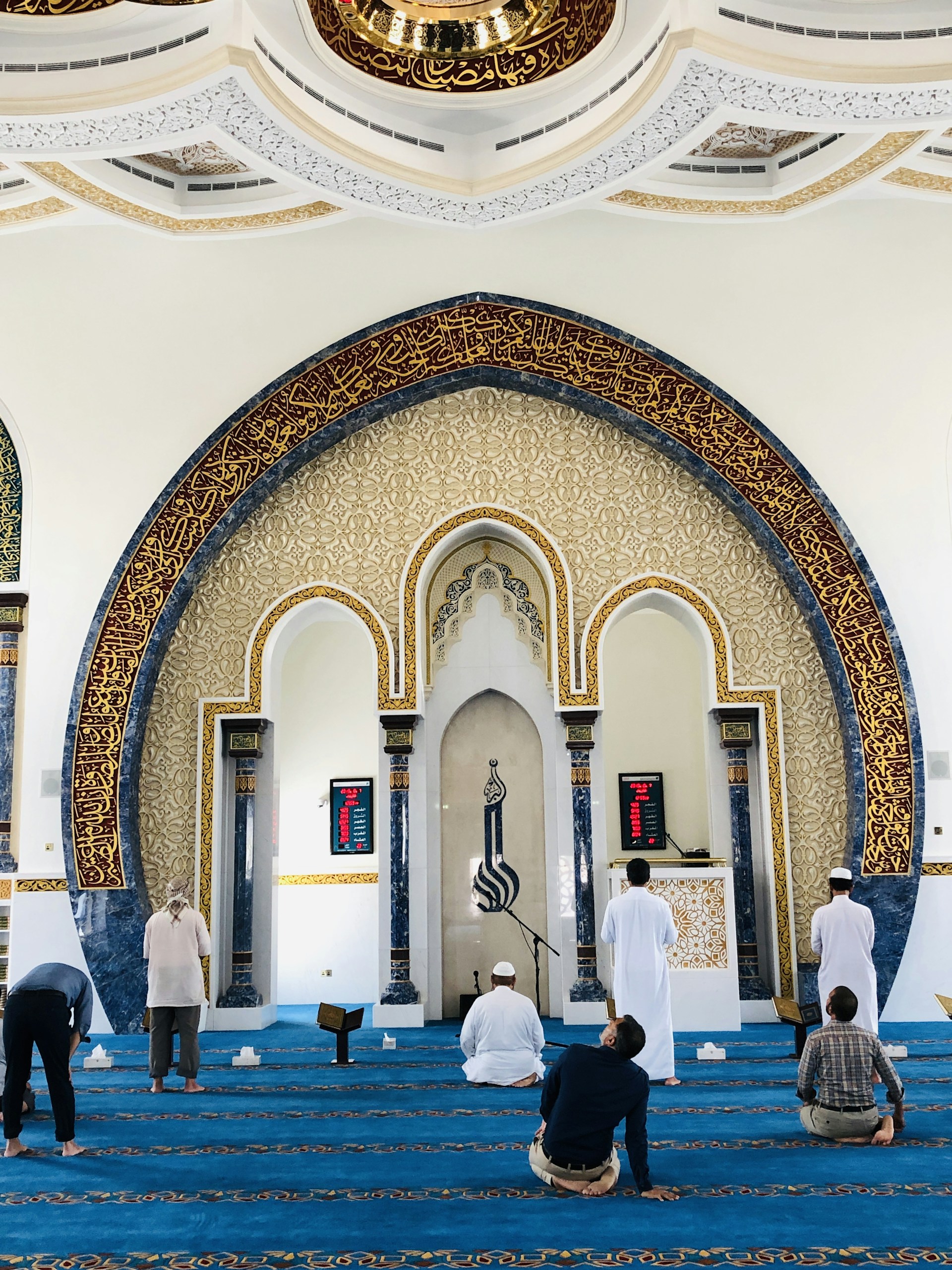 people standing in front of white and brown concrete building