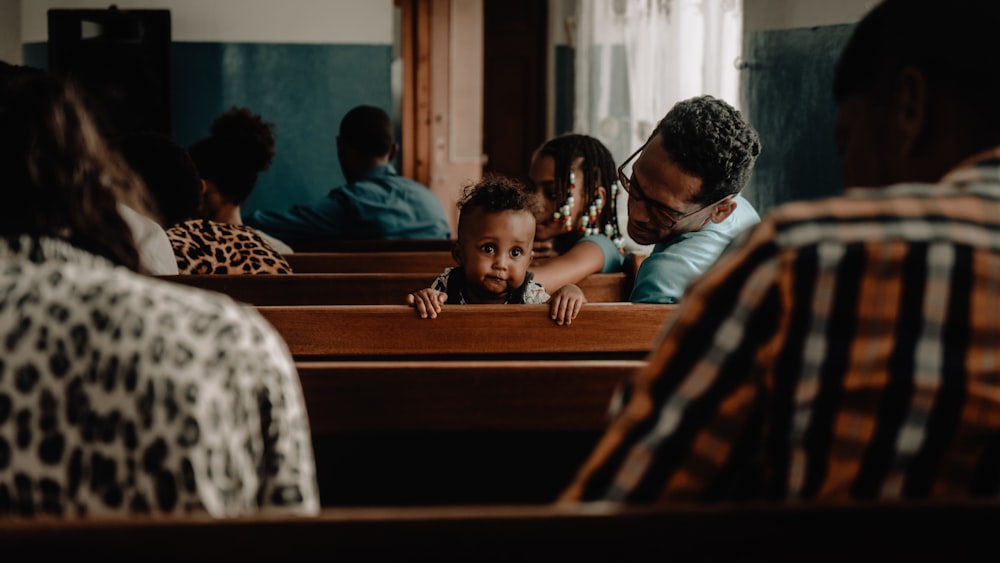 woman in black and white shirt sitting beside boy in blue shirt