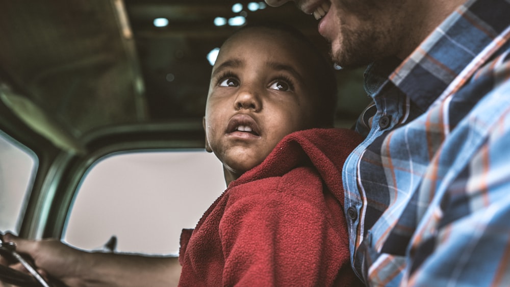 man in red hoodie sitting inside car