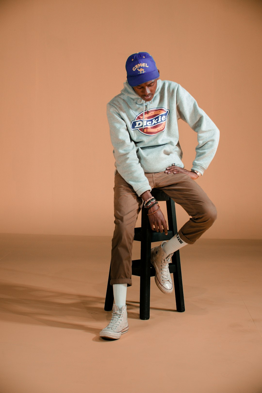 man in white sweater and blue cap riding on black and brown bicycle