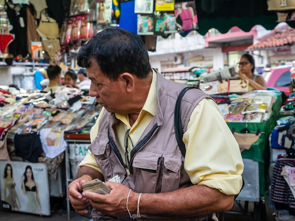 man in yellow polo shirt holding smartphone