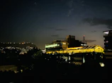 Nighttime cityscape featuring industrial architecture and subtle lighting.