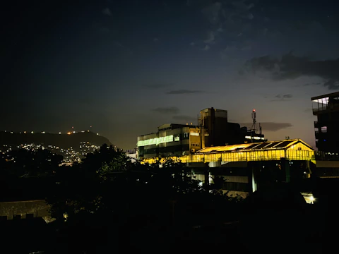 Nighttime cityscape featuring industrial architecture and subtle lighting.