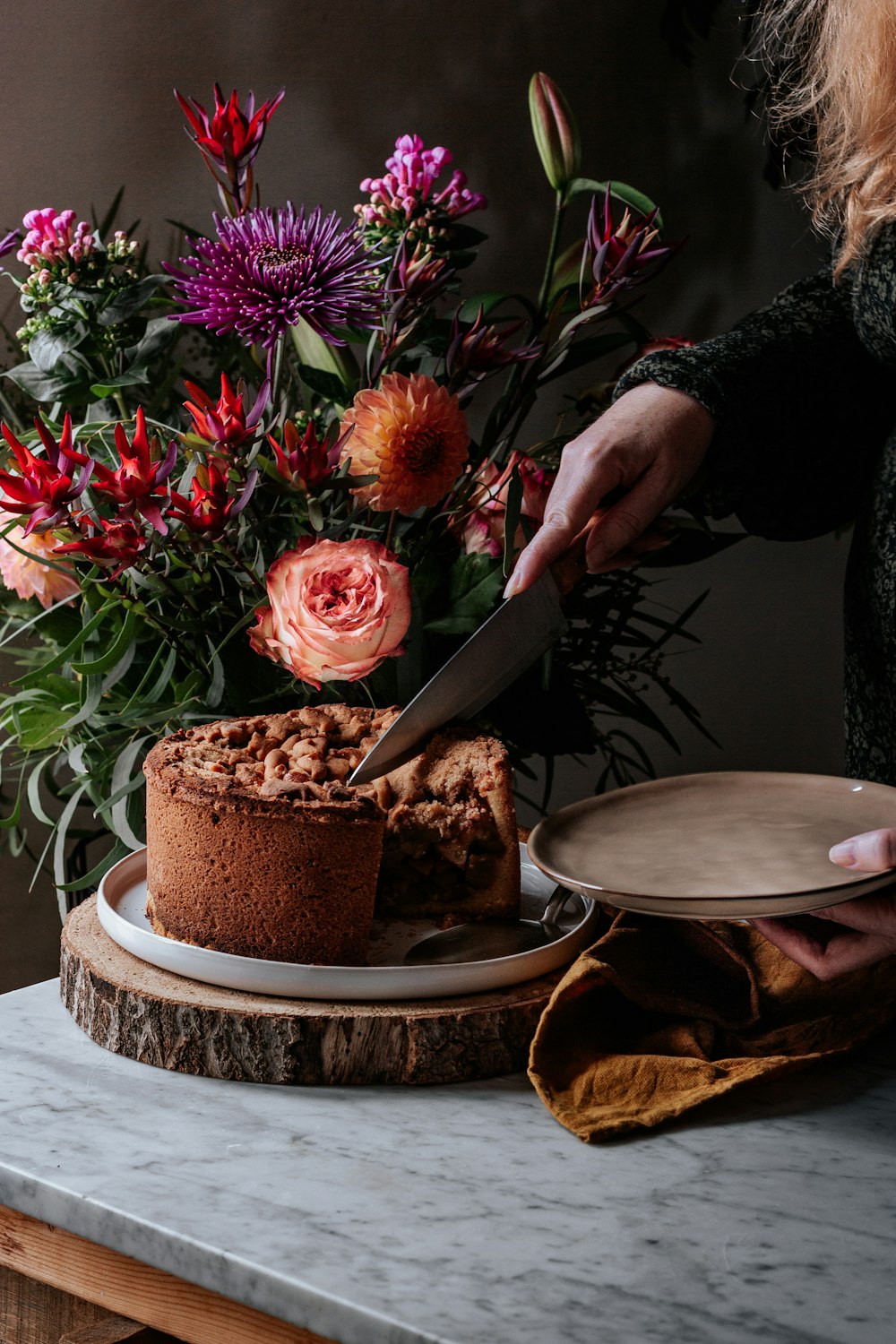 person holding knife slicing cake