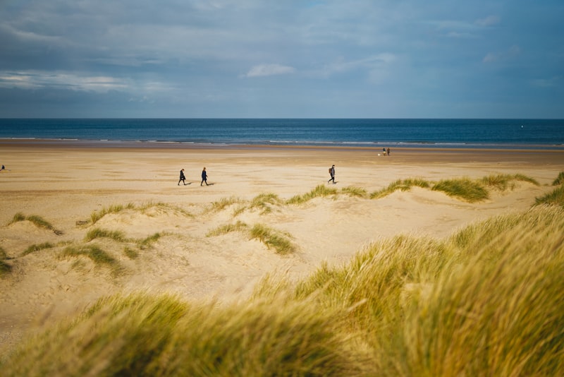 Wide surf beach backed by tall dunes at Holywell Bay