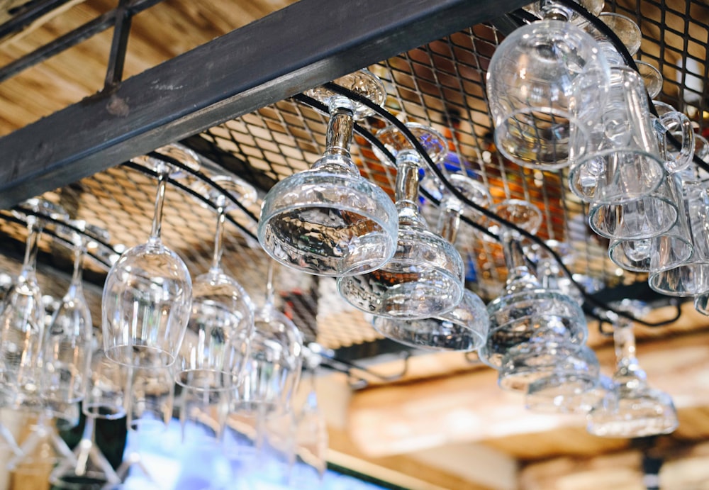 a bunch of wine glasses hanging from a rack