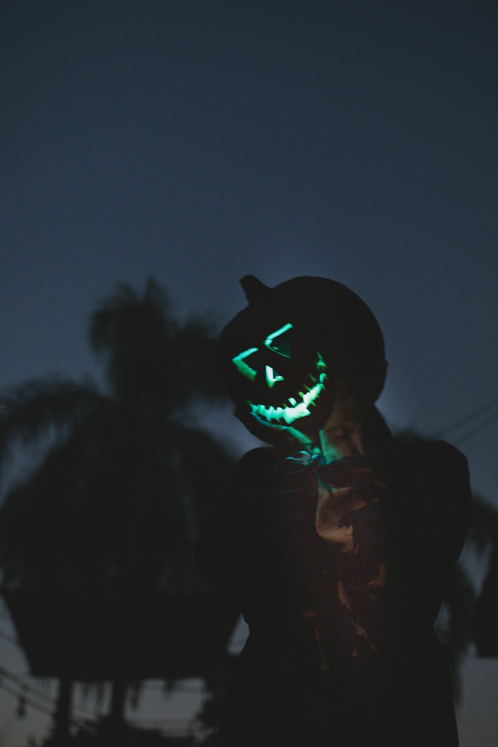 man in black hoodie wearing black and green mask