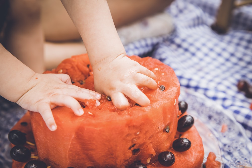 person holding orange fruit with black berries