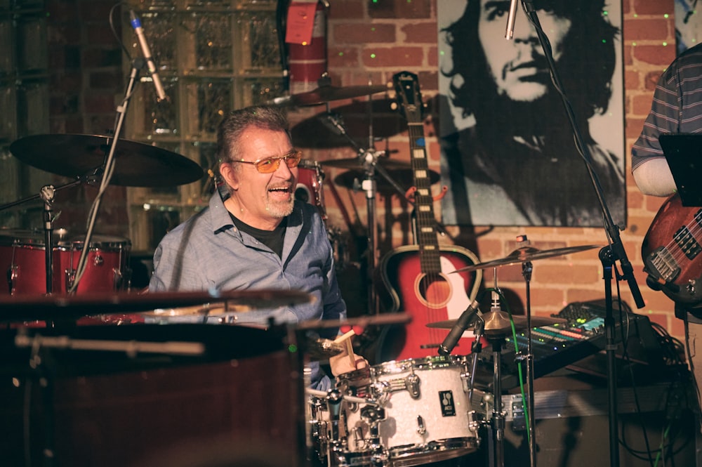 man in black jacket playing drum set