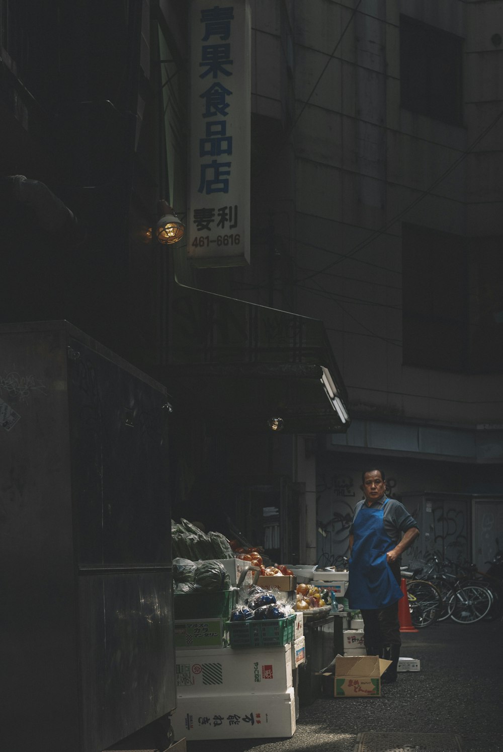 빨간 티셔츠와 파란색 데님 청바지를 입은 남자가 밤에 음식 가판대 근처에 서 있다