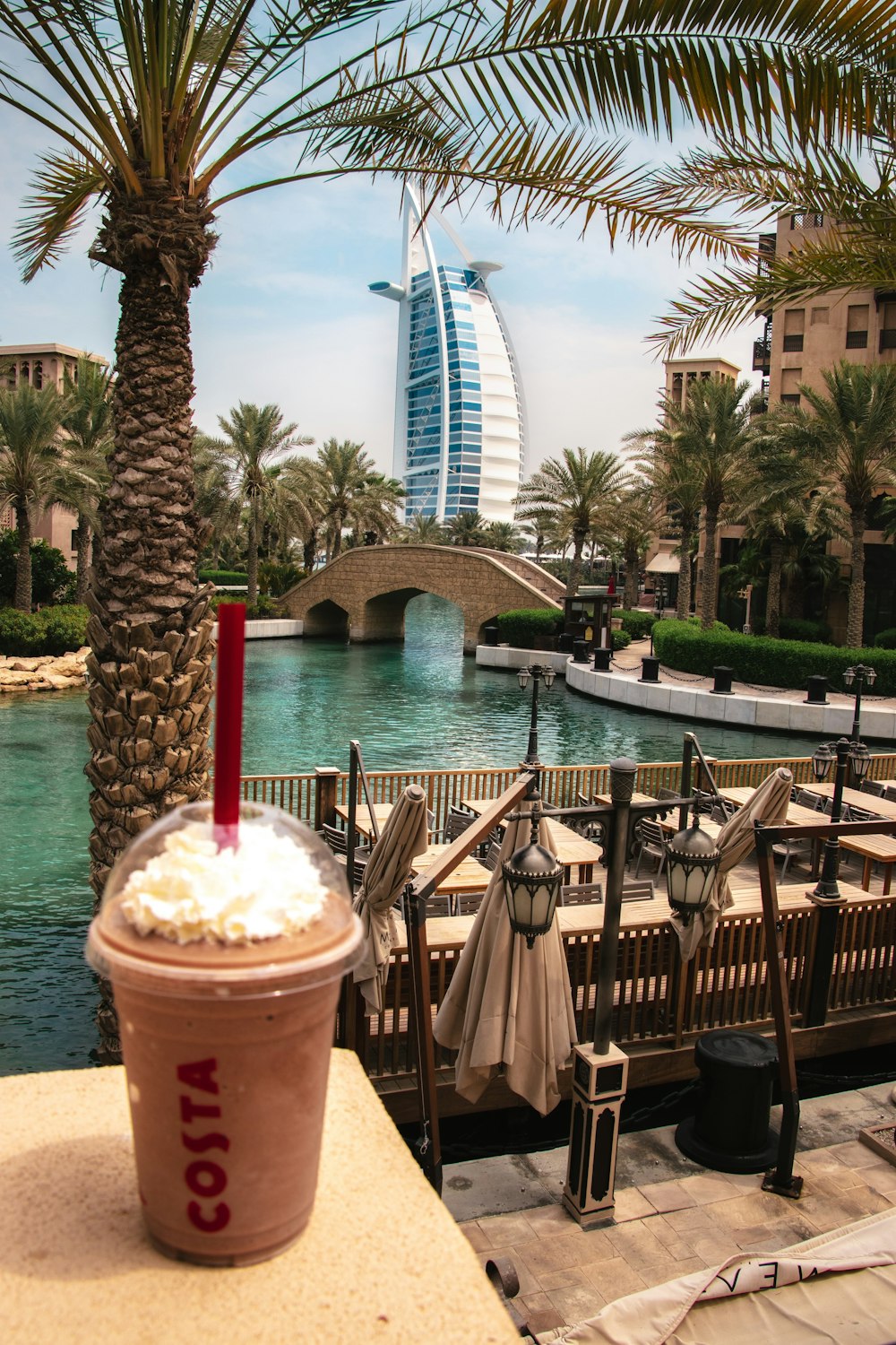 brown wooden chairs and tables near swimming pool during daytime